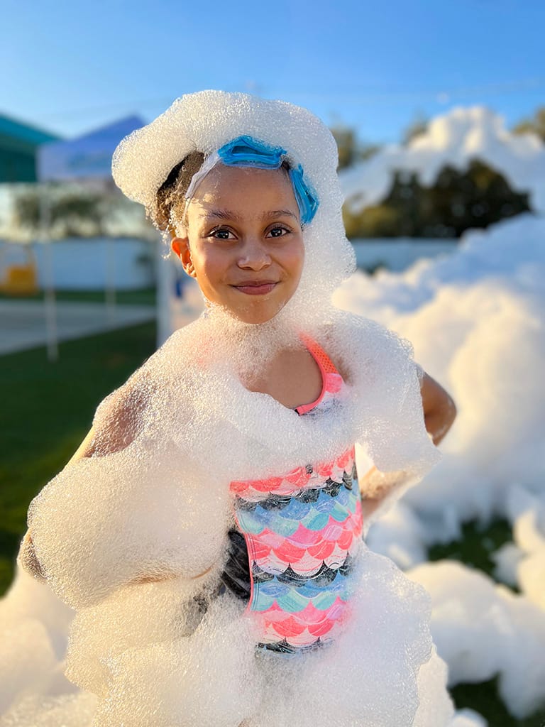A kid is covered in bubbly foam