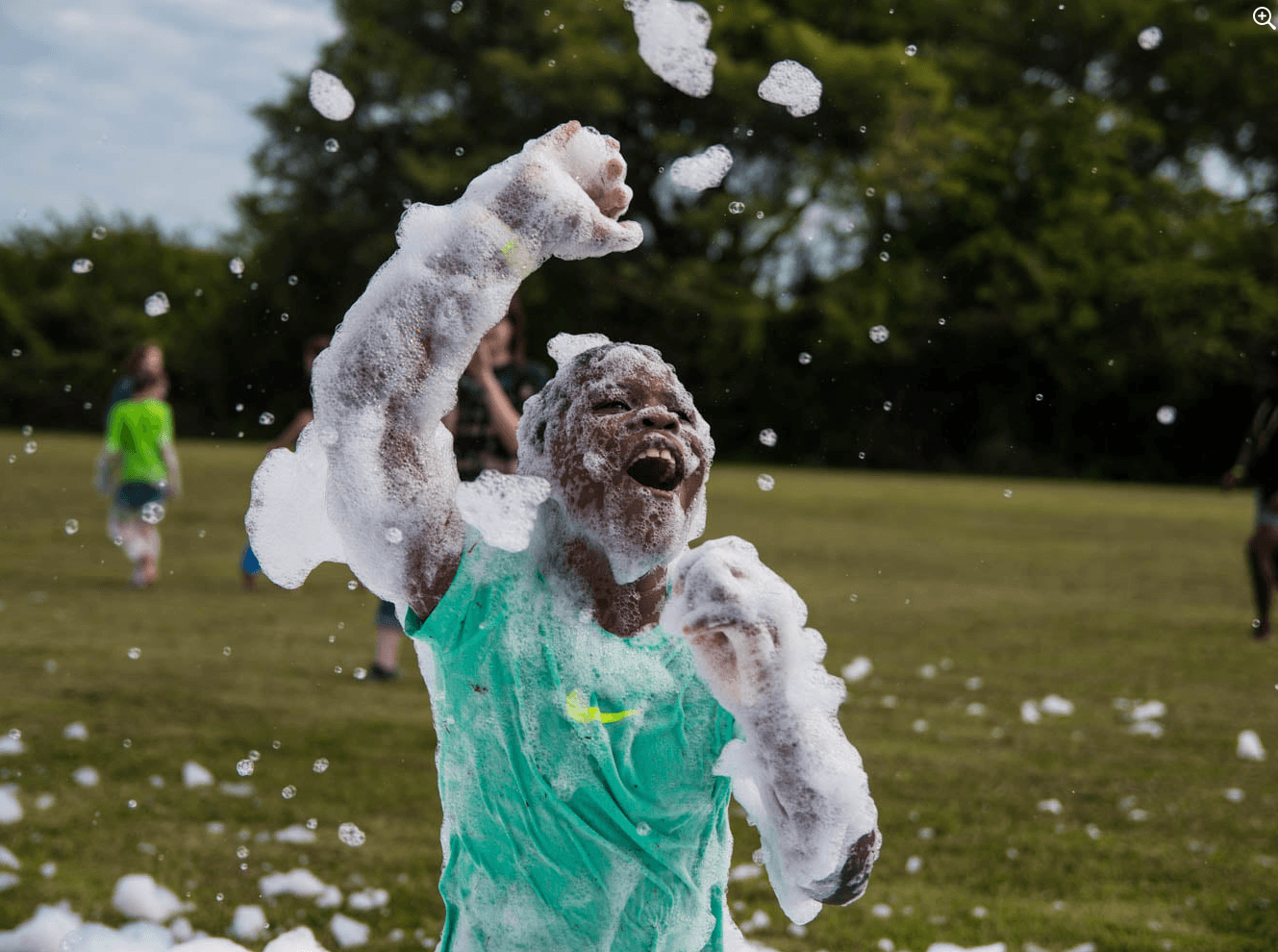 Kid in field covered in foam